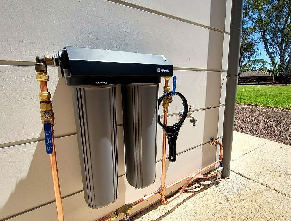 Whole-house water filtration unit on an exterior wall