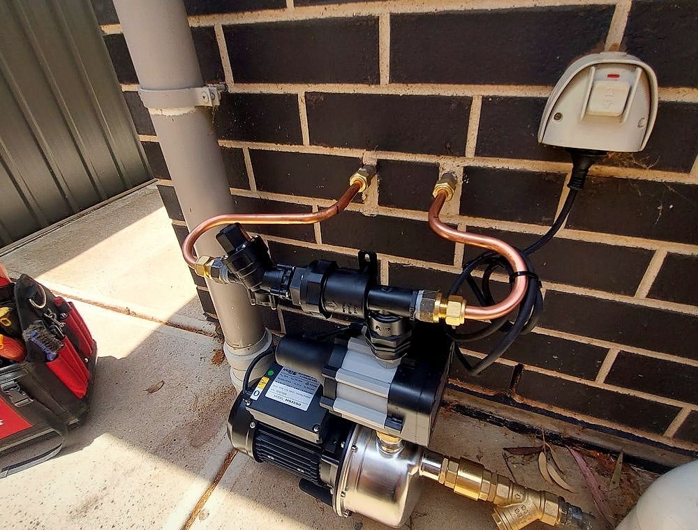 Gas meter and copper gas line work on a brick wall